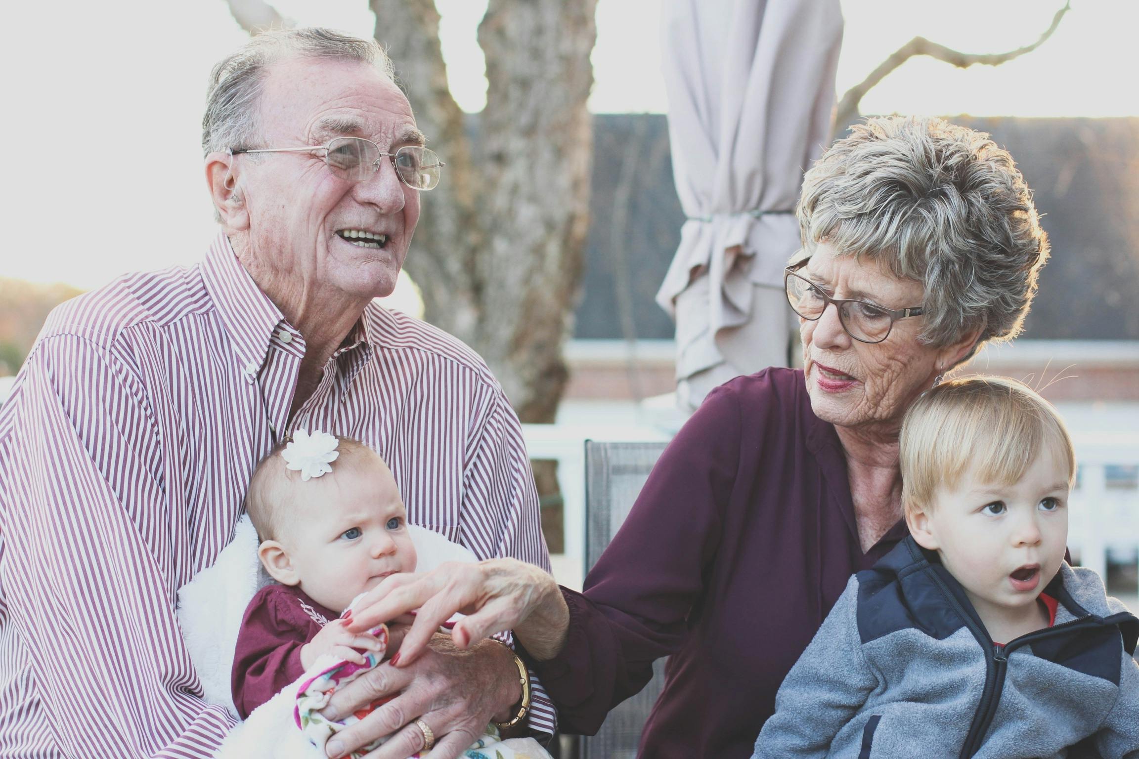 Grandparents smiling with grandchildren, showing the special relationships that life insurance can protect and provide for